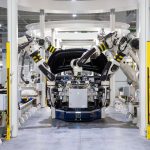 Robôs industriais trabalham na montagem de um automóvel em uma fábrica moderna.