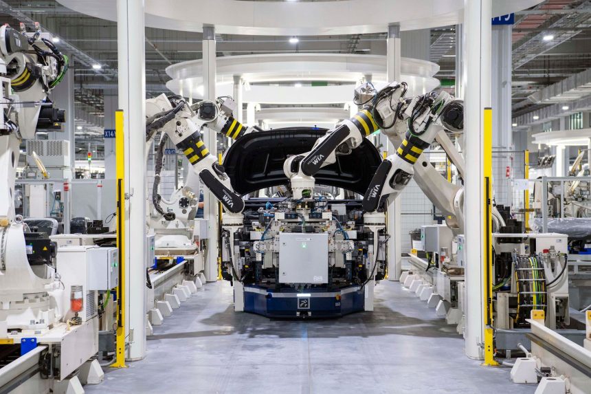 Robôs industriais trabalham na montagem de um automóvel em uma fábrica moderna.