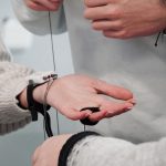 Mãos interagindo com um dispositivo eletrônico, em uma cena que representa tecnologia e colaboração.